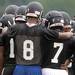 A Ypsilanti Community High School football player puts his arms around teammates as they huddle during practice in the rain at the school on Monday, August 12, 2013. Melanie Maxwell | AnnArbor.com